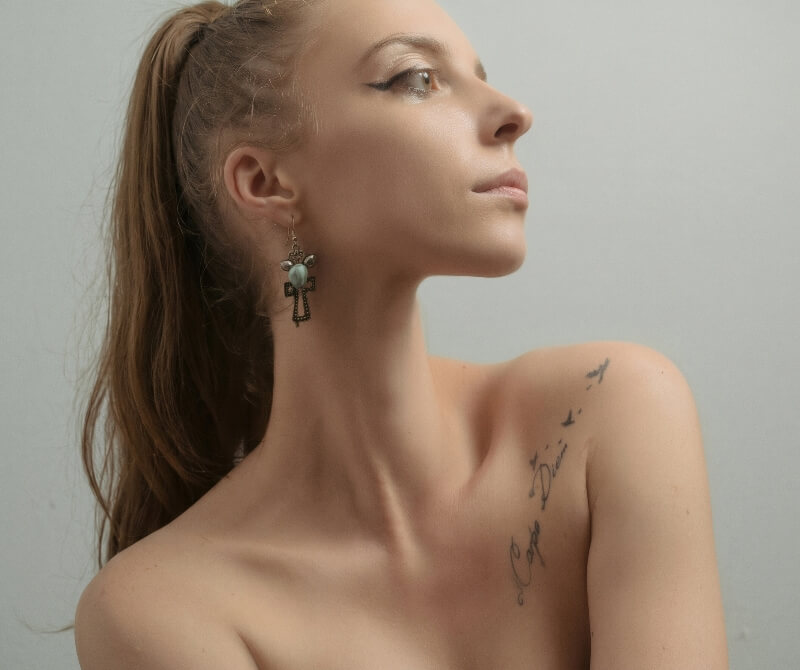 Woman with a script tattoo on her shoulder and upper chest.